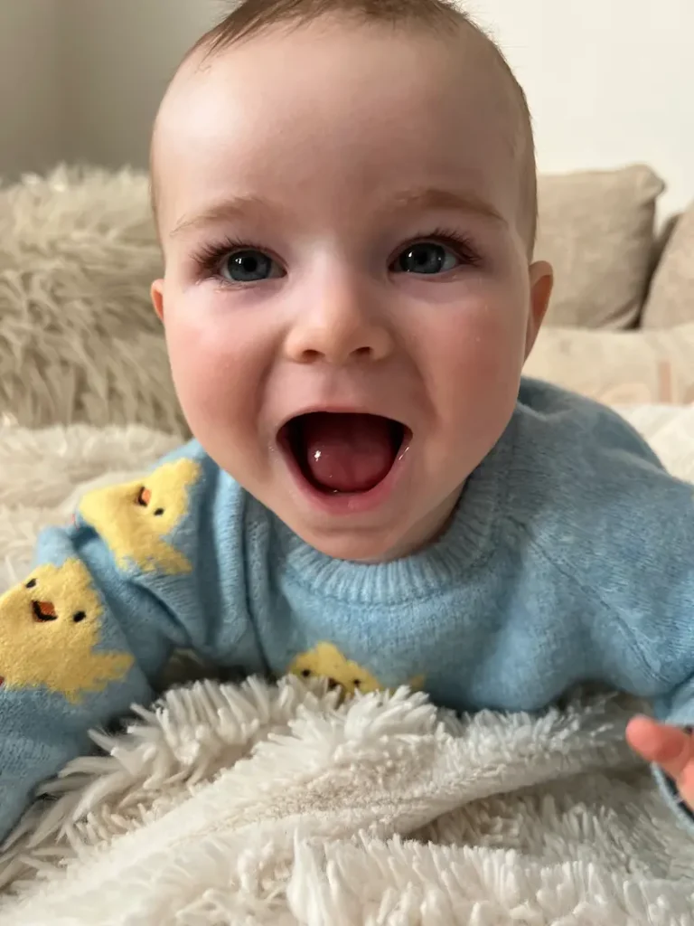baby boy smiling in blue jumper