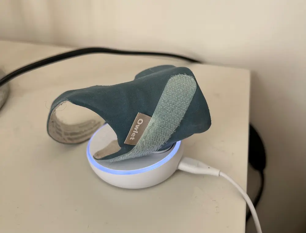 Owlet Sock on the white base station.